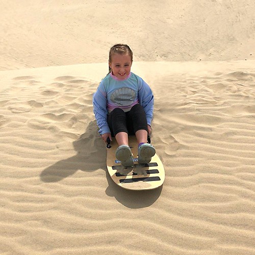 Young girl sand sledding on a Venomous Sand Sled.